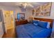 Cozy bedroom with wood-look floors and a ceiling fan with blue decorative touches at 502 Dewolf Rd, Brandon, FL 33511