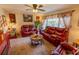 Comfortable living room featuring red leather furniture, decorative curtains, and ample natural light at 502 Dewolf Rd, Brandon, FL 33511