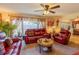 Bright living room featuring red leather furniture, decorative curtains, and a ceiling fan at 502 Dewolf Rd, Brandon, FL 33511