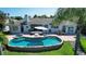 Aerial perspective of the backyard with a pool, spa, patio, waterfront, and immaculate landscaping at 511 Island Way, Clearwater Beach, FL 33767