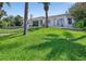 Lovely backyard with a lush lawn, waterfront access, a patio, and a serene outdoor setting at 511 Island Way, Clearwater Beach, FL 33767