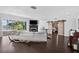 Stylish living room featuring hardwood floors, a fireplace, and large windows that open to the outdoors for seamless living at 511 Island Way, Clearwater Beach, FL 33767