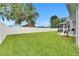 Lush green backyard with a white fence, providing privacy and a sense of tranquility at 5117 Whispering Leaf Trl, Valrico, FL 33596