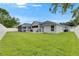 Spacious green backyard featuring a screened-in porch and mature trees for shade at 5117 Whispering Leaf Trl, Valrico, FL 33596