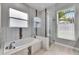 Bathroom showcasing tub, walk-in shower with glass door and windows providing natural light at 5117 Whispering Leaf Trl, Valrico, FL 33596