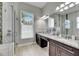 Bright bathroom with double vanity, granite countertop, updated fixtures, and walk-in shower at 5117 Whispering Leaf Trl, Valrico, FL 33596