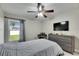 The bedroom features a large TV, wood-look dresser, and window at 5117 Whispering Leaf Trl, Valrico, FL 33596