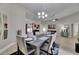 Open concept dining area with wood-look tile flooring, modern decor, and adjacent living area at 5117 Whispering Leaf Trl, Valrico, FL 33596