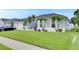 Charming home featuring lush green lawn, complemented by palm trees and beautiful white rock landscaping at 5117 Whispering Leaf Trl, Valrico, FL 33596
