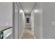 Well-lit hallway with neutral paint, modern light fixture and wood-look floors at 5117 Whispering Leaf Trl, Valrico, FL 33596