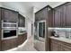 Modern kitchen with stainless steel appliances, dark wood cabinets, and tile flooring at 5117 Whispering Leaf Trl, Valrico, FL 33596