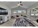 Bright living room with a vaulted ceiling, modern furniture, large windows, and tile flooring at 5117 Whispering Leaf Trl, Valrico, FL 33596