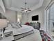 Relaxing main bedroom suite with a tray ceiling, plush carpet, and access to a private outdoor space at 5117 Whispering Leaf Trl, Valrico, FL 33596