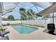 This backyard features a refreshing screened-in pool with comfortable seating and shade at 5117 Whispering Leaf Trl, Valrico, FL 33596