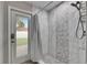 Modern shower showcasing stylish tile work, rainfall showerhead and a door leading to the backyard at 5117 Whispering Leaf Trl, Valrico, FL 33596