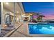 Covered lanai features outdoor kitchen, dining area and sparkling pool with waterfront views at dusk at 5287 61St S Ave, St Petersburg, FL 33715