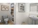 Elegant powder room with a pedestal sink, decorative mirror, and built-in shelving at 5287 61St S Ave, St Petersburg, FL 33715