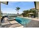 An inviting pool with a spa overlooks the serene water, surrounded by lush palms, providing a tranquil retreat at 5287 61St S Ave, St Petersburg, FL 33715