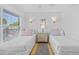 This bedroom features two twin beds, a woven dresser, and wall lighting at 5445 Gulf Blvd # 210, St Pete Beach, FL 33706
