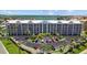 Exterior elevation of condo building, lush landscaping, and ample parking at 5445 Gulf Blvd # 210, St Pete Beach, FL 33706