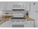 Kitchen features stainless steel appliances, tiled backsplash, and granite countertops at 5445 Gulf Blvd # 210, St Pete Beach, FL 33706