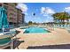 Community pool with lounge chairs and palm trees at 5445 Gulf Blvd # 210, St Pete Beach, FL 33706