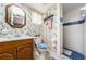 Bathroom with patterned wallpaper, tiled floors, a sink, a toilet, and a tiled shower at 5919 35Th N Ave, St Petersburg, FL 33703