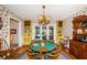 Dining room featuring a round table, bright yellow cabinetry, and vintage-style wallpaper at 5919 35Th N Ave, St Petersburg, FL 33703
