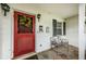 Inviting front porch with a red door, decorative wreath, and cozy seating area at 5919 35Th N Ave, St Petersburg, FL 33703