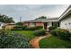 Charming home with a red door, brick facade, landscaped yard, and a stone pathway at 5919 35Th N Ave, St Petersburg, FL 33703
