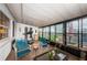 Sunroom features tiled floor, glass windows overlooking pool, with treadmill and seating at 5919 35Th N Ave, St Petersburg, FL 33703