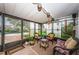 Bright sunroom features tile floors, wicker seating, and sliding windows showcasing the beautiful pool and backyard at 5919 35Th N Ave, St Petersburg, FL 33703