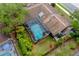 Aerial view of the backyard, complete with a screened-in pool, lush landscaping, and a well-maintained exterior at 625 Fayette S Dr, Safety Harbor, FL 34695
