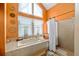 Bathroom featuring an orange wall, large bathtub, and separate standing shower at 625 Fayette S Dr, Safety Harbor, FL 34695