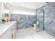 Modern bath with marble tile, dual vanities, and a frameless glass shower, gold fixtures and blue accent wall at 6920 13Th N Ave, St Petersburg, FL 33710