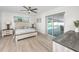 Comfortable bedroom with modern ceiling fan, light wood flooring, and access to the pool deck at 6920 13Th N Ave, St Petersburg, FL 33710