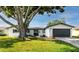 Charming single-story home with a well-manicured lawn and mature tree in the front yard at 6920 13Th N Ave, St Petersburg, FL 33710