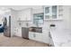 Bright kitchen featuring white cabinets, a stainless steel sink and appliances, and light wood flooring at 6920 13Th N Ave, St Petersburg, FL 33710