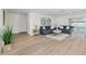 Bright living room with two blue sofas, a light wood floor, and sliding glass doors to the pool at 6920 13Th N Ave, St Petersburg, FL 33710