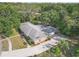 Aerial view showcasing the home's location, surrounded by lush greenery, with a view of the roof and driveway at 7002 Doreen St, Tampa, FL 33617