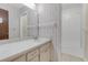 Well-lit bathroom featuring a large vanity mirror, sink, and enclosed shower at 7002 Doreen St, Tampa, FL 33617