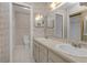 This bathroom features a dual sink vanity, tiled floors, and a walk-in shower at 7002 Doreen St, Tampa, FL 33617