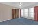 This bedroom features a closet, large windows with coverings, carpet, and a ceiling fan at 7002 Doreen St, Tampa, FL 33617