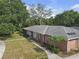 Street view of a charming brick home with a well-kept lawn, pathway, and an inviting double door entrance at 7002 Doreen St, Tampa, FL 33617