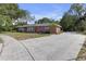 A single-story brick home with a large driveway and well-manicured front lawn at 7002 Doreen St, Tampa, FL 33617