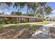 Charming single-story brick home featuring a well-manicured lawn, mature trees, and a welcoming front entrance at 7002 Doreen St, Tampa, FL 33617