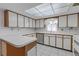 Bright kitchen featuring white cabinetry, updated appliances, and light countertops at 7002 Doreen St, Tampa, FL 33617