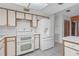 Bright kitchen featuring white cabinets, double oven, and modern white refrigerator at 7002 Doreen St, Tampa, FL 33617