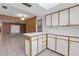 Kitchen with white cabinets, breakfast bar, and tile flooring open to other rooms at 7002 Doreen St, Tampa, FL 33617