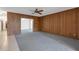 Comfortable living room with carpet flooring, wood paneling, and ceiling fan at 7002 Doreen St, Tampa, FL 33617